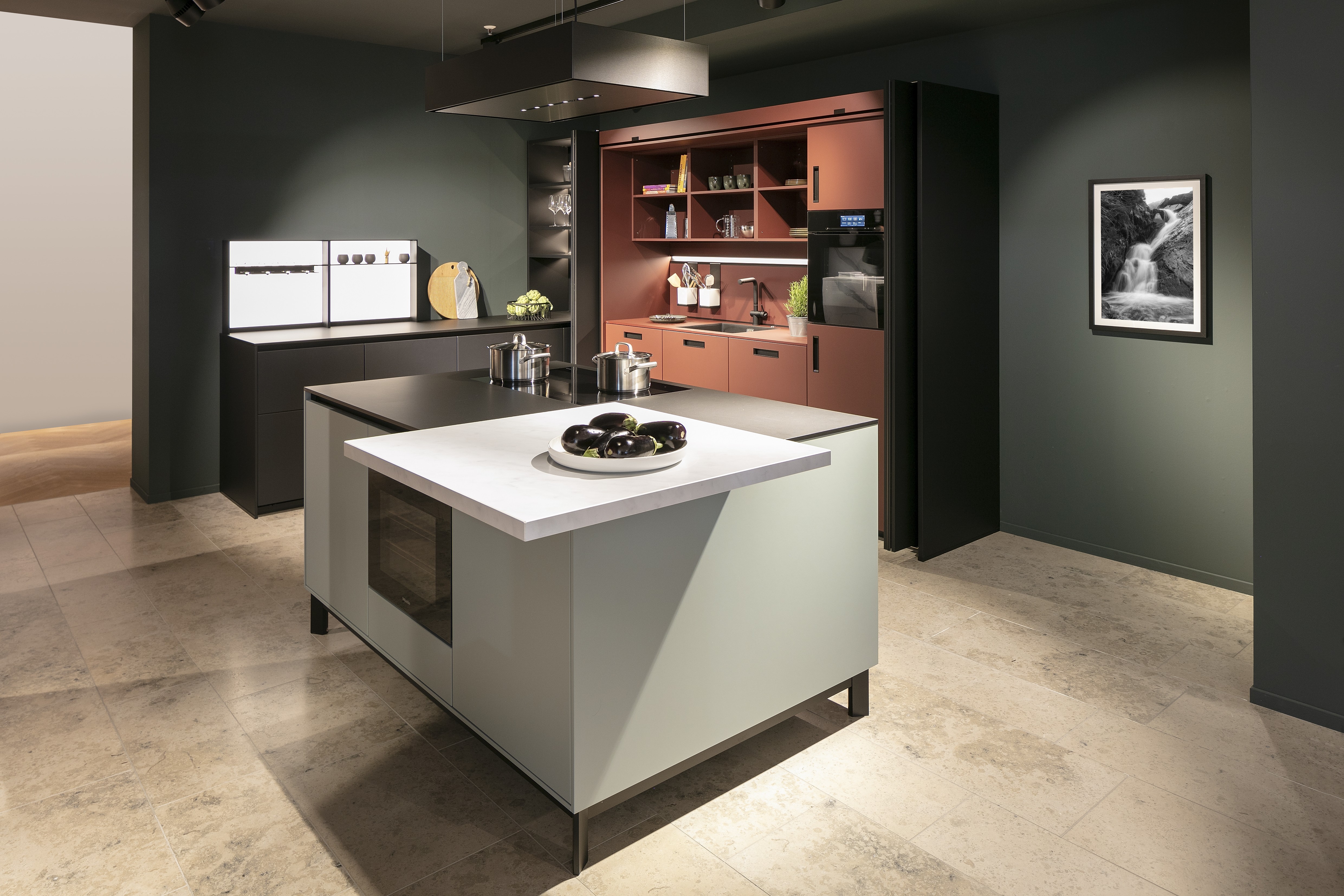 Next125-Küche in Indischrot mit Onyxschwarz - mit Kücheninsel im Vordergrund