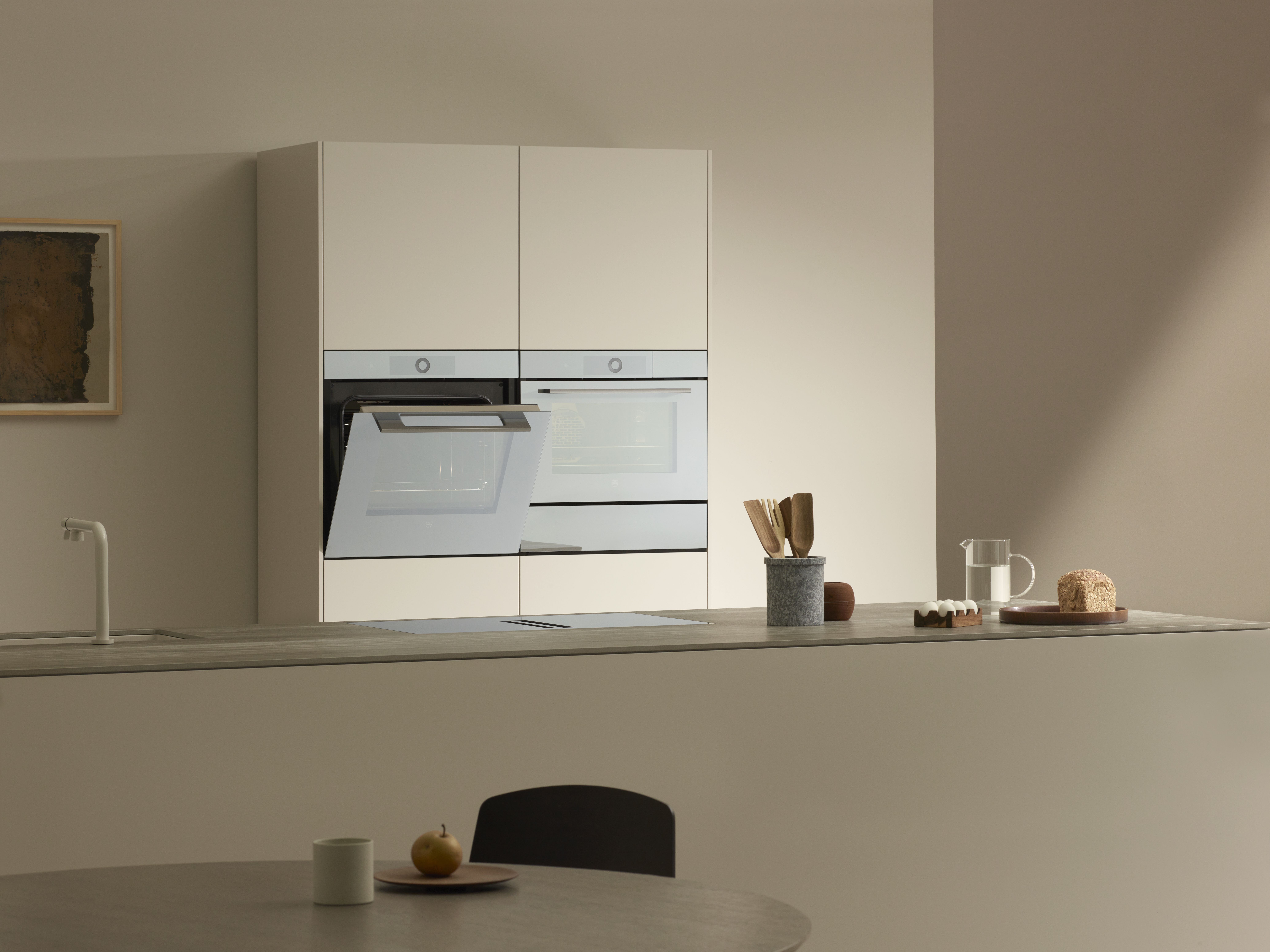 V-ZUG Backofen halb offen in grifflosem Gerätehochschrank hinter freistehender Küchentheke